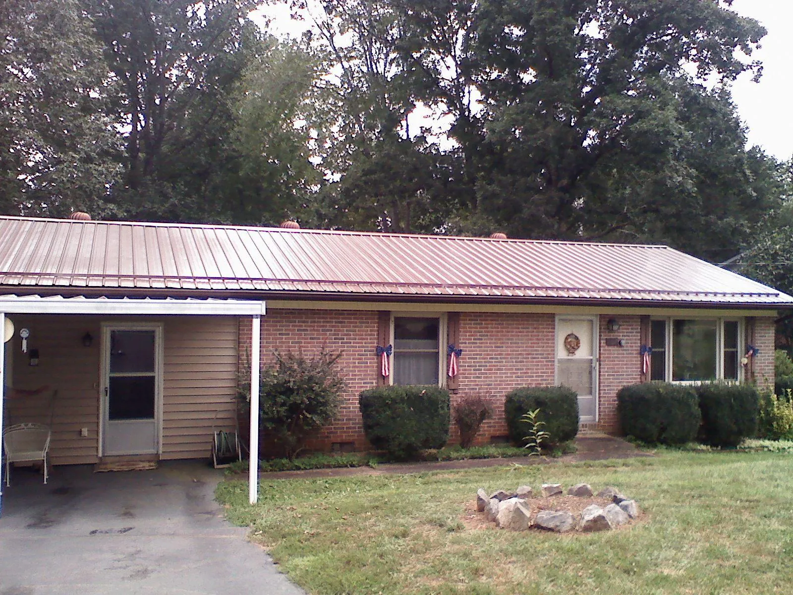 Bronze metal roof and carport on a brick ranch home — Roof Repair work by our crew in New Philadelphia