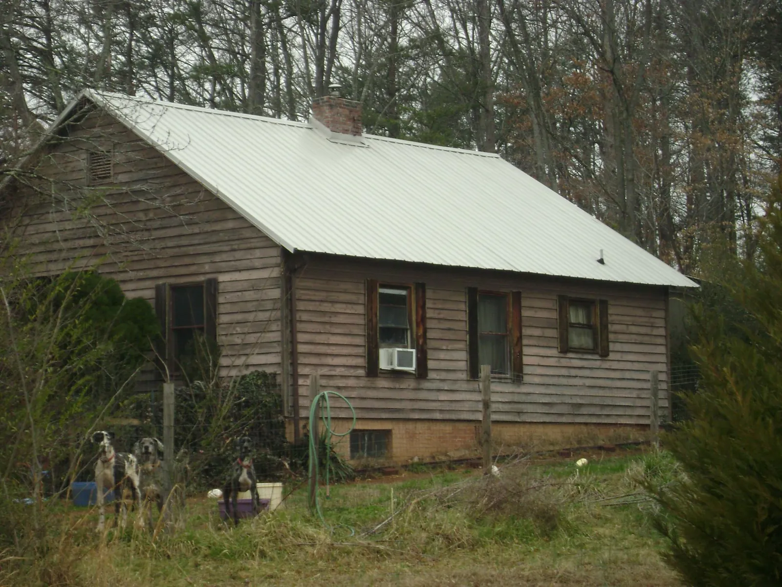 White metal roof on an old wood sided farmhouse, from a Metal Roof Installation job in New Philadelphia